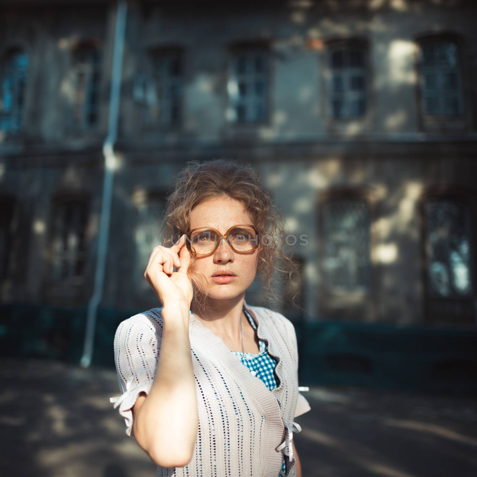 Funny girl student with glasses and a vintage dress outdoors