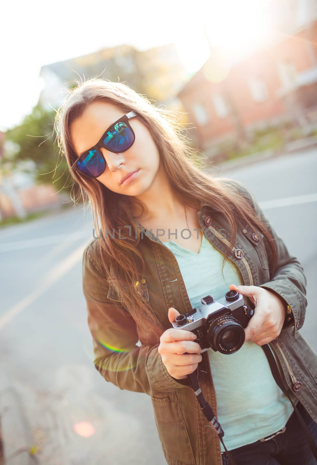 Close up lifestyle portrait of pretty young fashion brunette in sun glasses on the sun at sunset