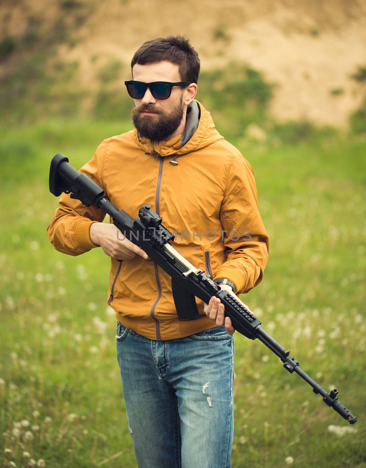 A man with an automatic rifle outdoor