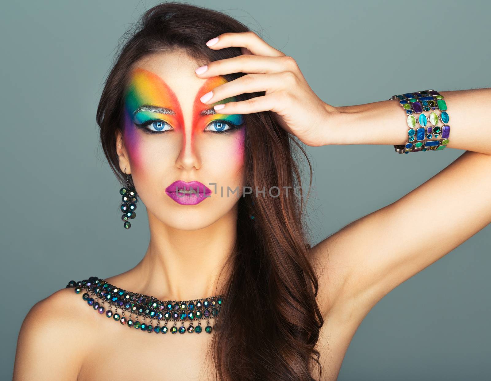 Portrait of a young beautiful girl with a fashion bright multicolored makeup of eyes