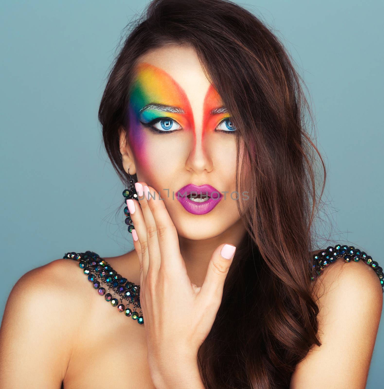 Portrait of a young beautiful girl with a fashion bright multicolored makeup of eyes