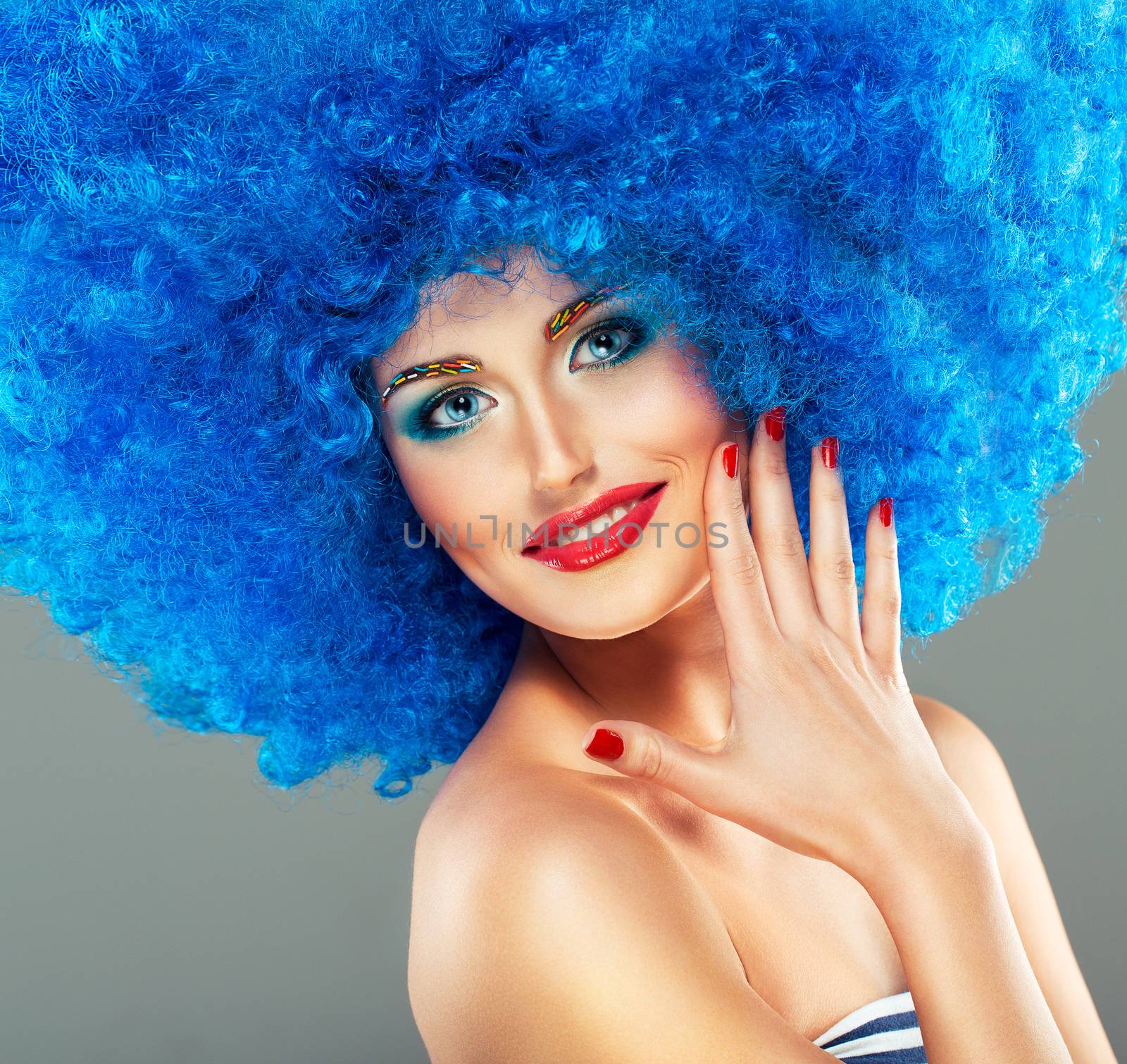 Portrait of a young beautiful girl with bright makeup, red lips in blue wig