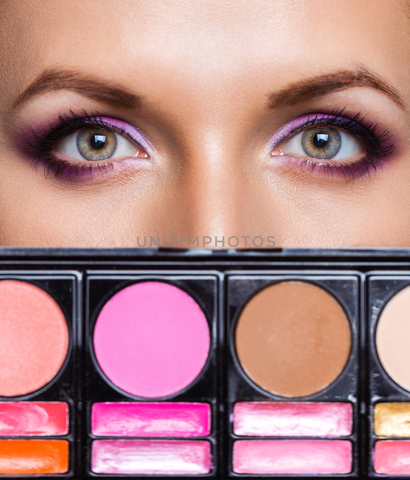 Closeup of beautiful womanish eyes with makeup kit and glamorous makeup