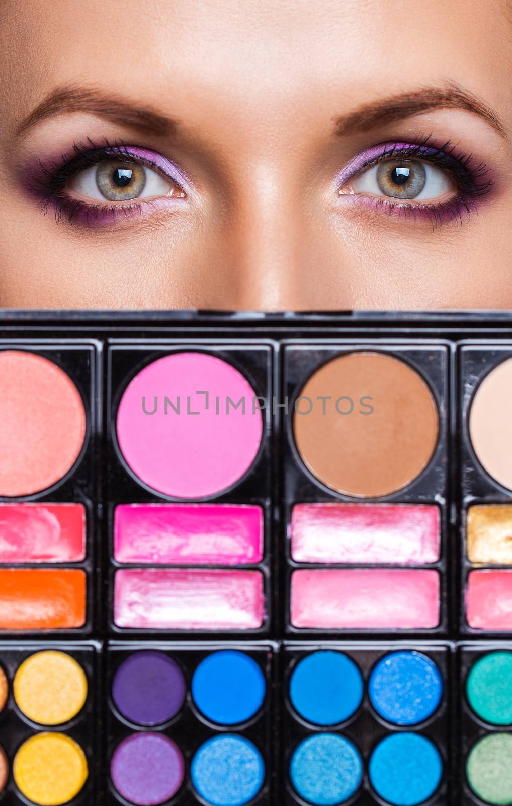 Closeup of beautiful womanish eyes with makeup kit and glamorous makeup