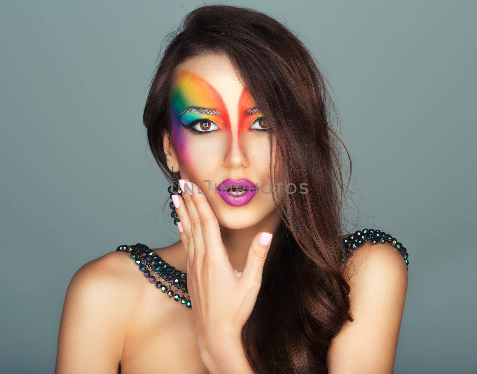 Portrait of a young beautiful girl with a fashion bright multicolored makeup of eyes