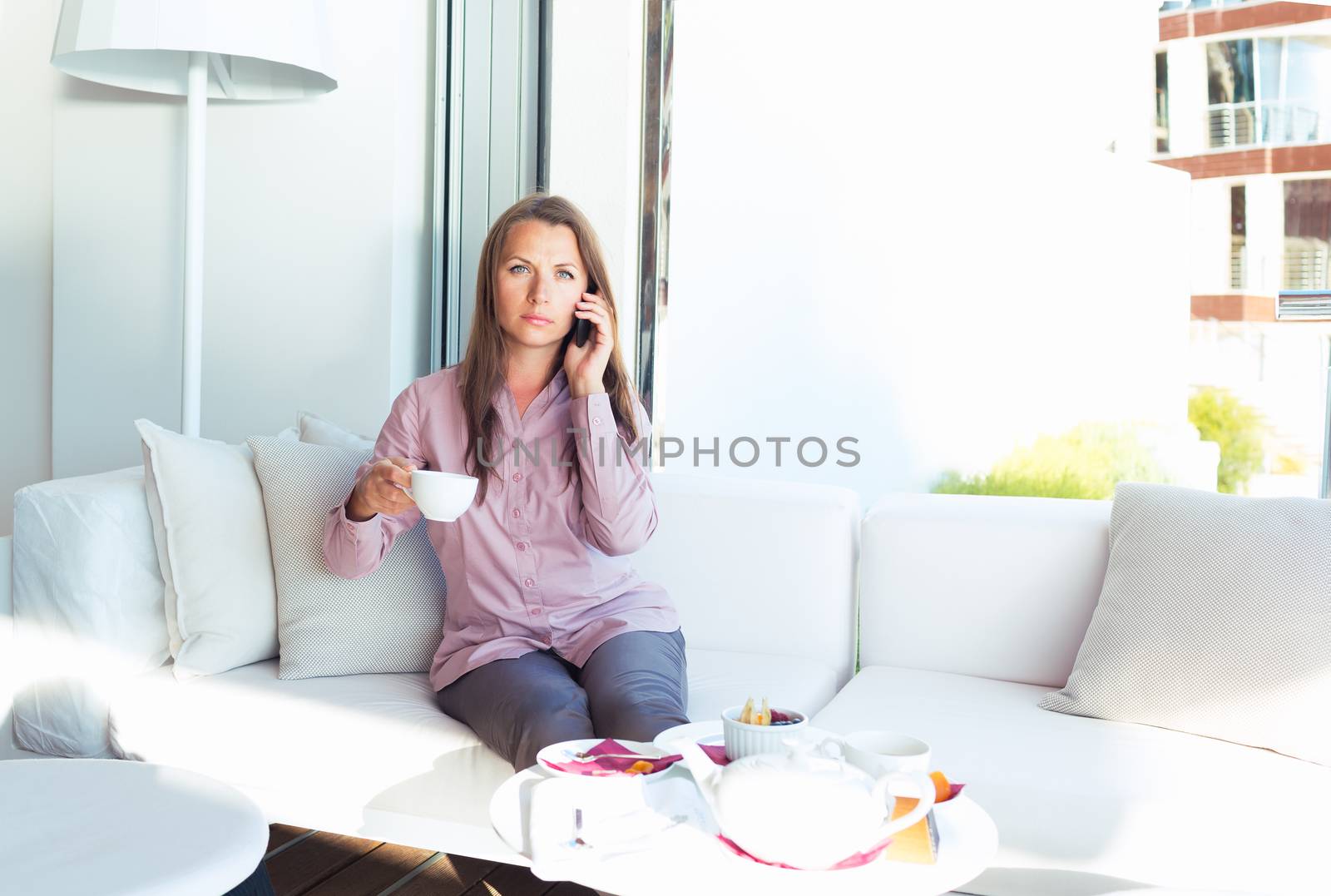 Businesswoman talking on the phone in a cafe by vlad_star