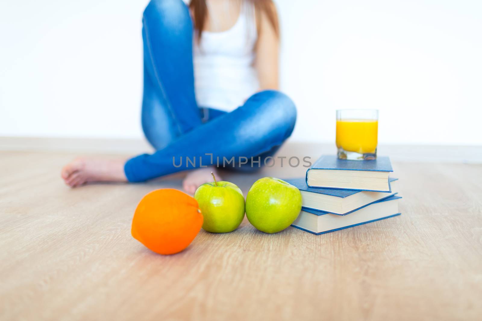 Young caucasian brunette with apple reading a book at home