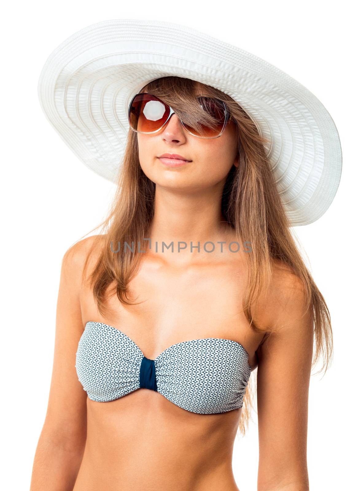 Portrait of a beautiful young woman posing in bikini, hat and sunglasses on white background