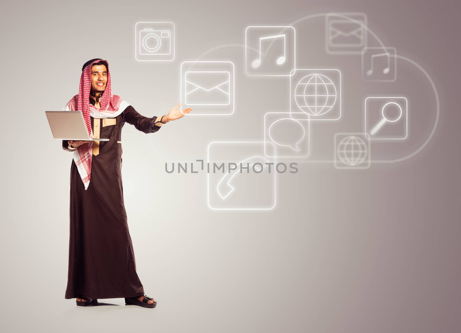 Young smiling arab with laptop shows virtual icons of the cloud service. Multimedia concept