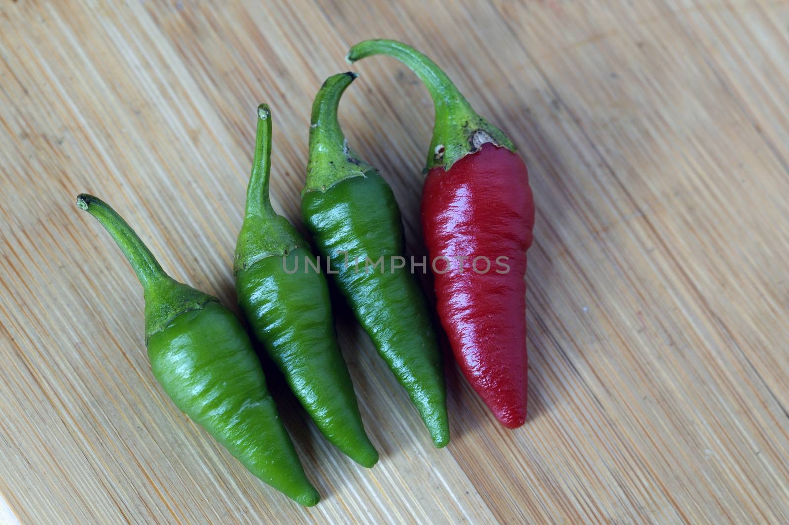 Red chilli with a group of green chilli, Being Different