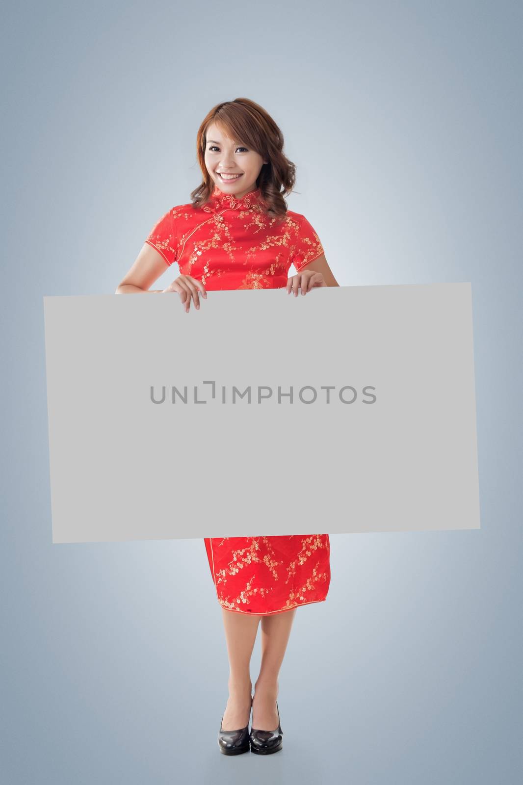 Attractive Chinese woman dress traditional cheongsam and hold blank board, full length portrait.