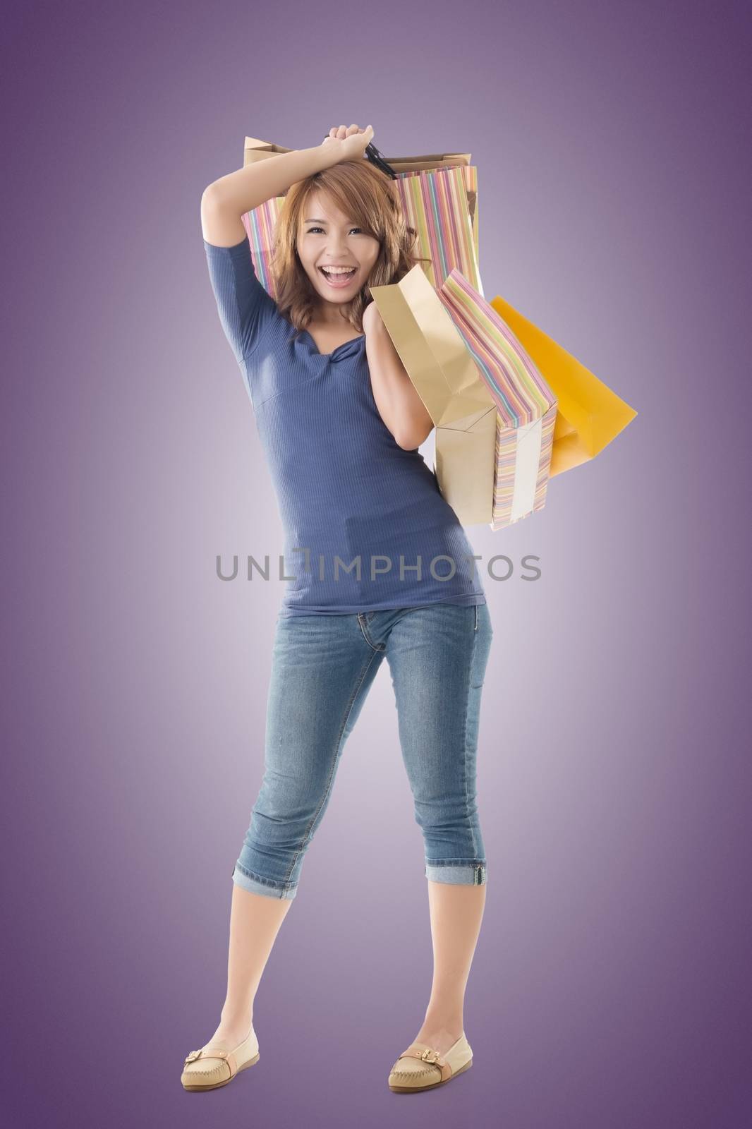 Cheerful shopping woman of Asian holding bags, isolated.