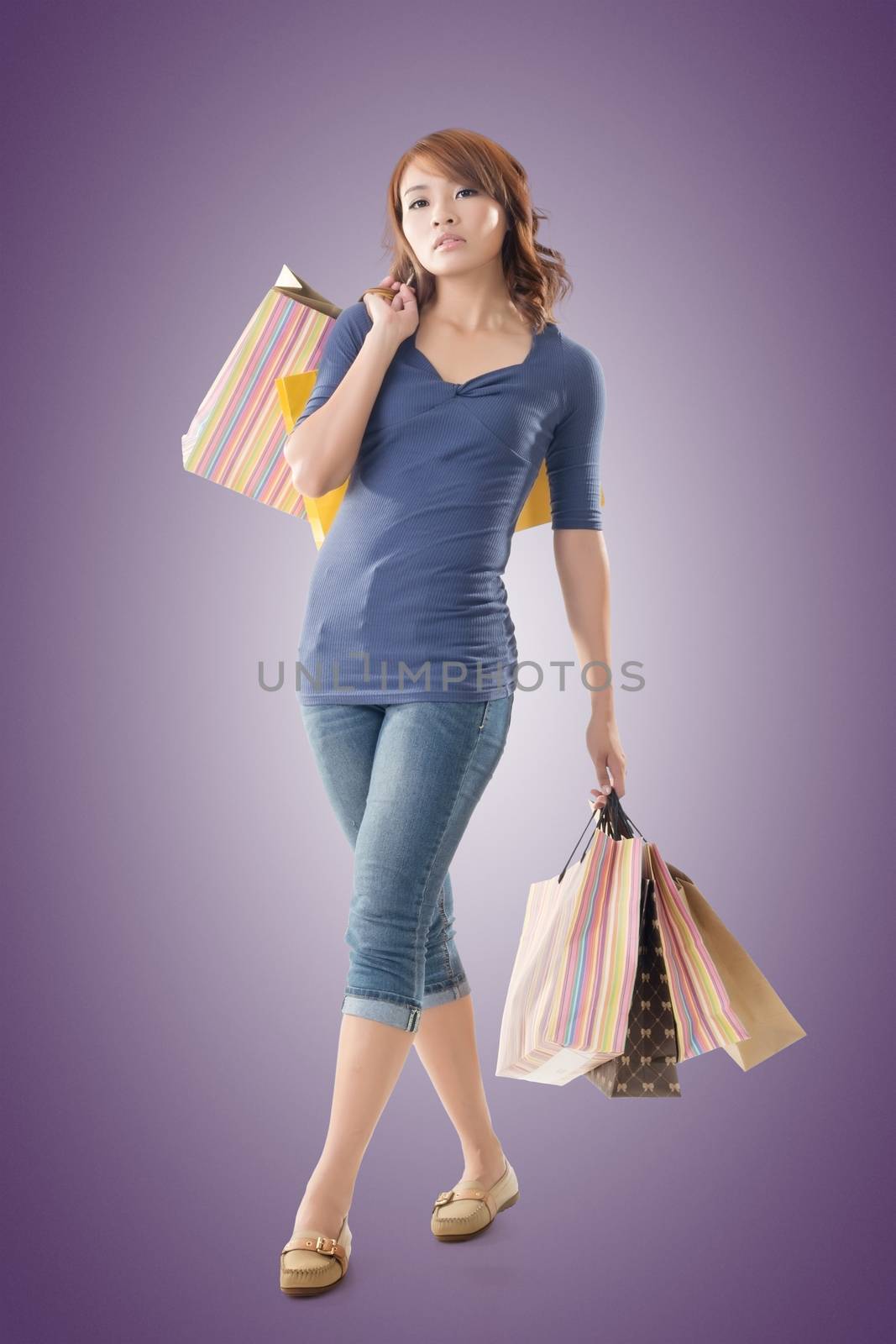 Confident shopping woman of Asian holding bags, isolated.