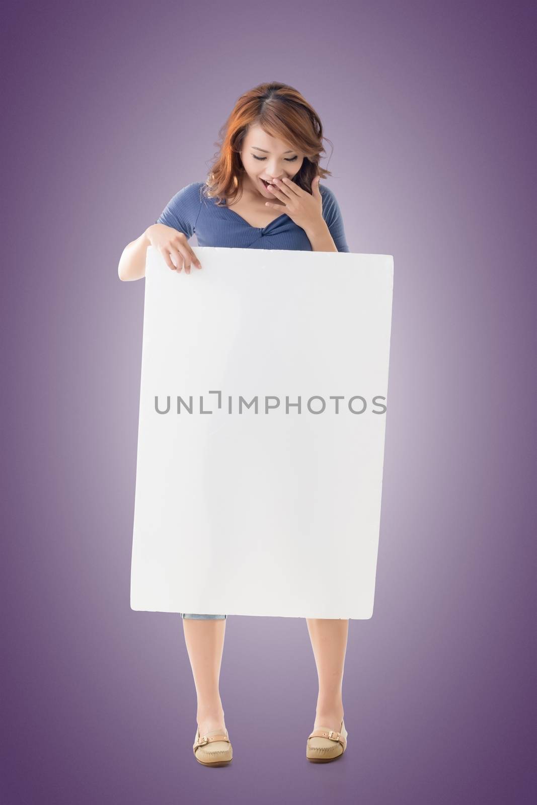 Excited Asian girl hold a blank board, full length portrait isolated.