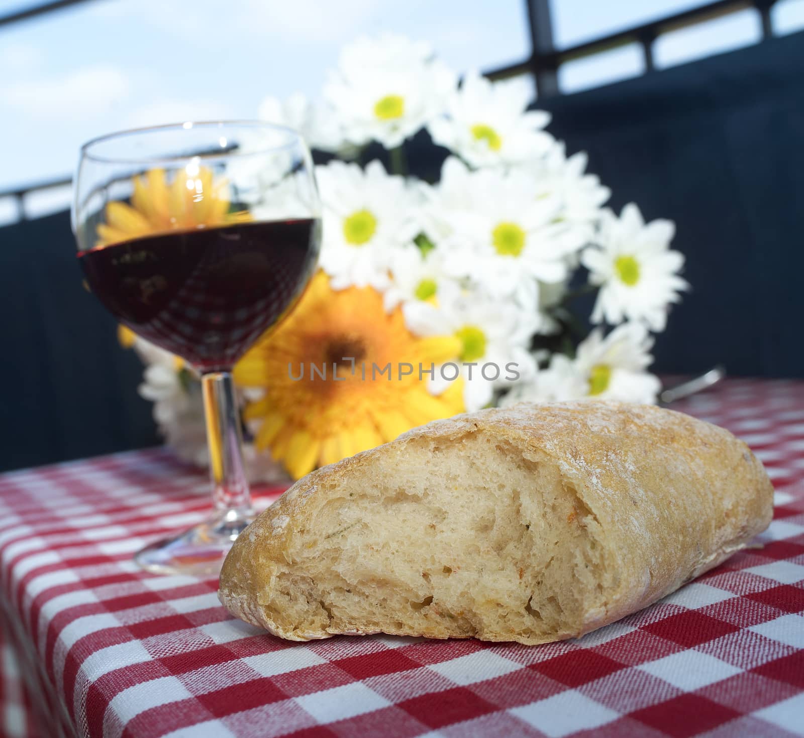 Wine and Bread on a table with some flowers
