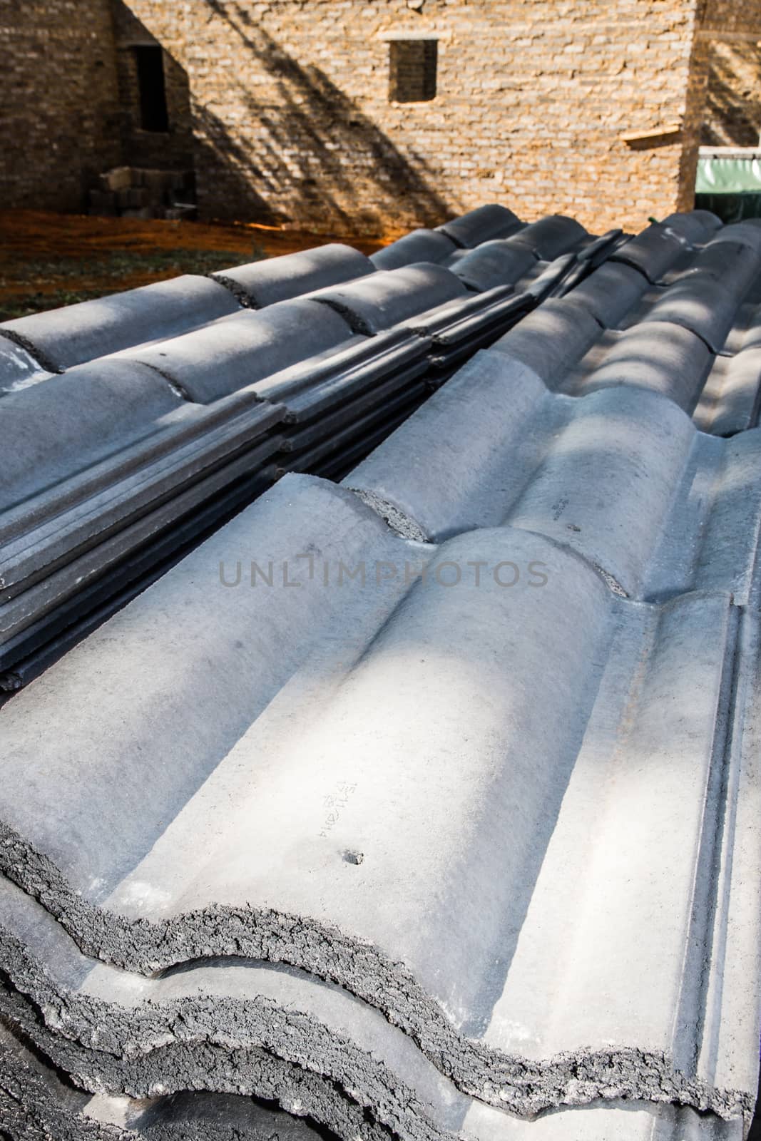 Stacked Roof Tiles beside the house it is ment for which is still in the process of being build.