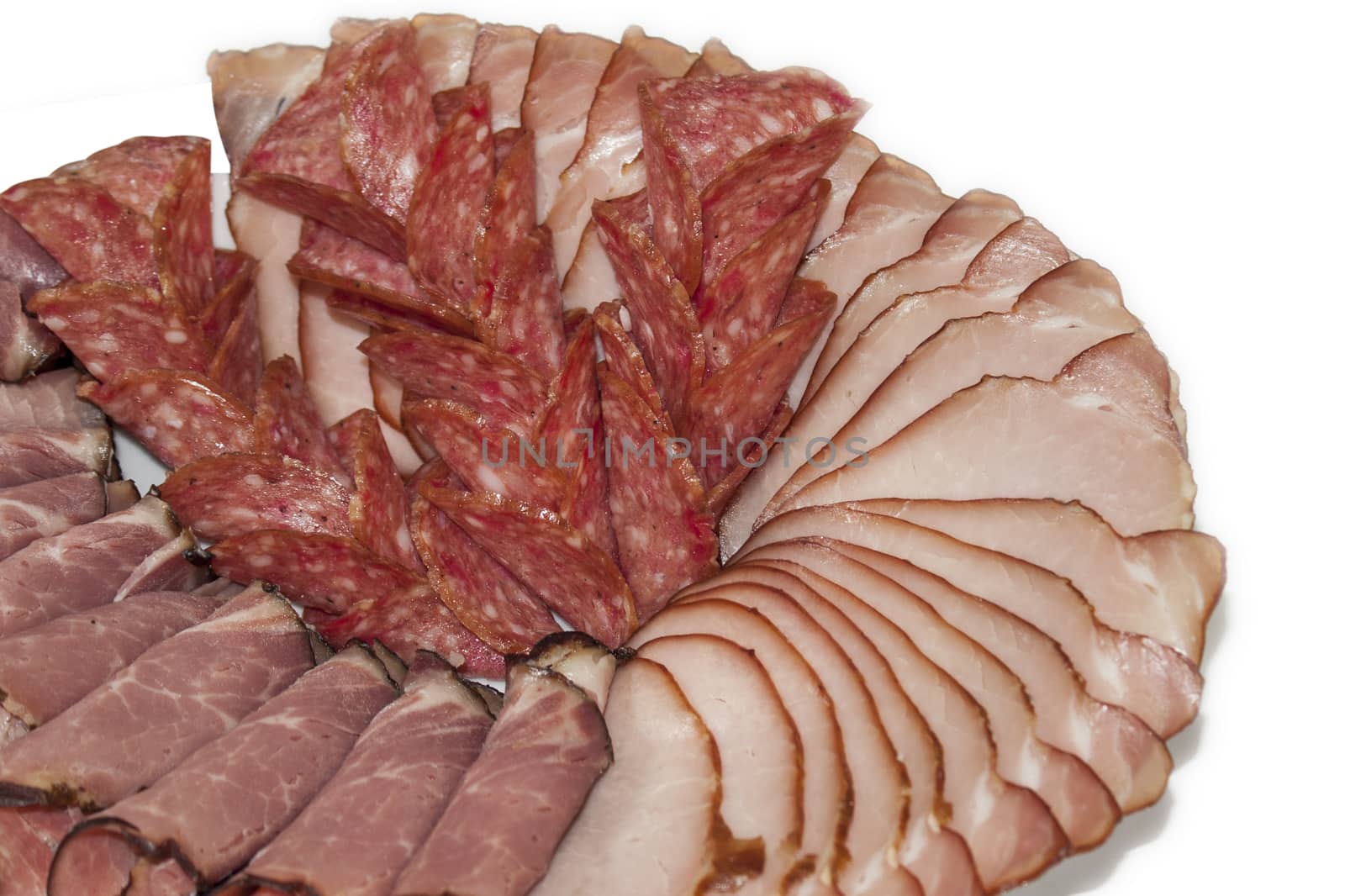 Cutted smoked sirloin, smoked ham and sausage on a plate.