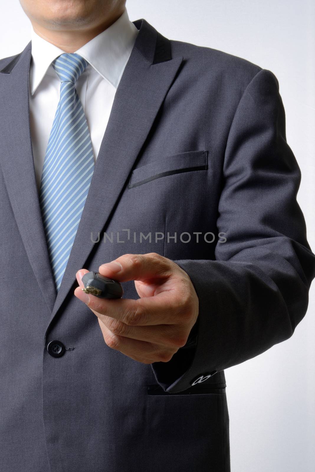 Businessman pushing remote a car key on white background