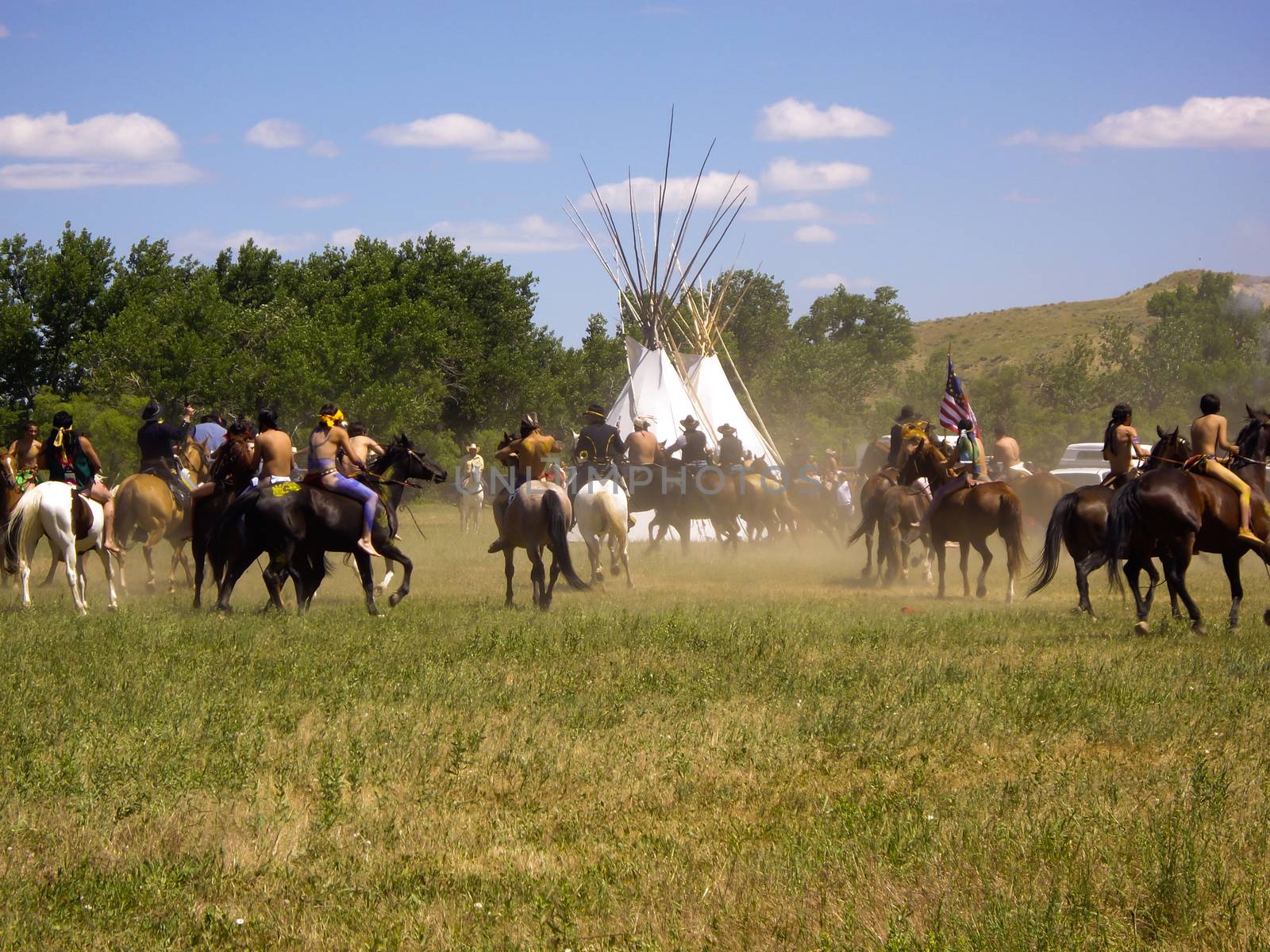 Crow Agency, Montana USA - June 27, 2009: Old and Modern worlds meet at Battle of the Little Bighorn Re-enactment. Reenactment of the Battle of the Little Bighorn known as Custer's Last Stand. Young American Indians of the Arapahoe, Cheyenne and Lakota tribes battle the U.S. 7th Cavalry soldiers.