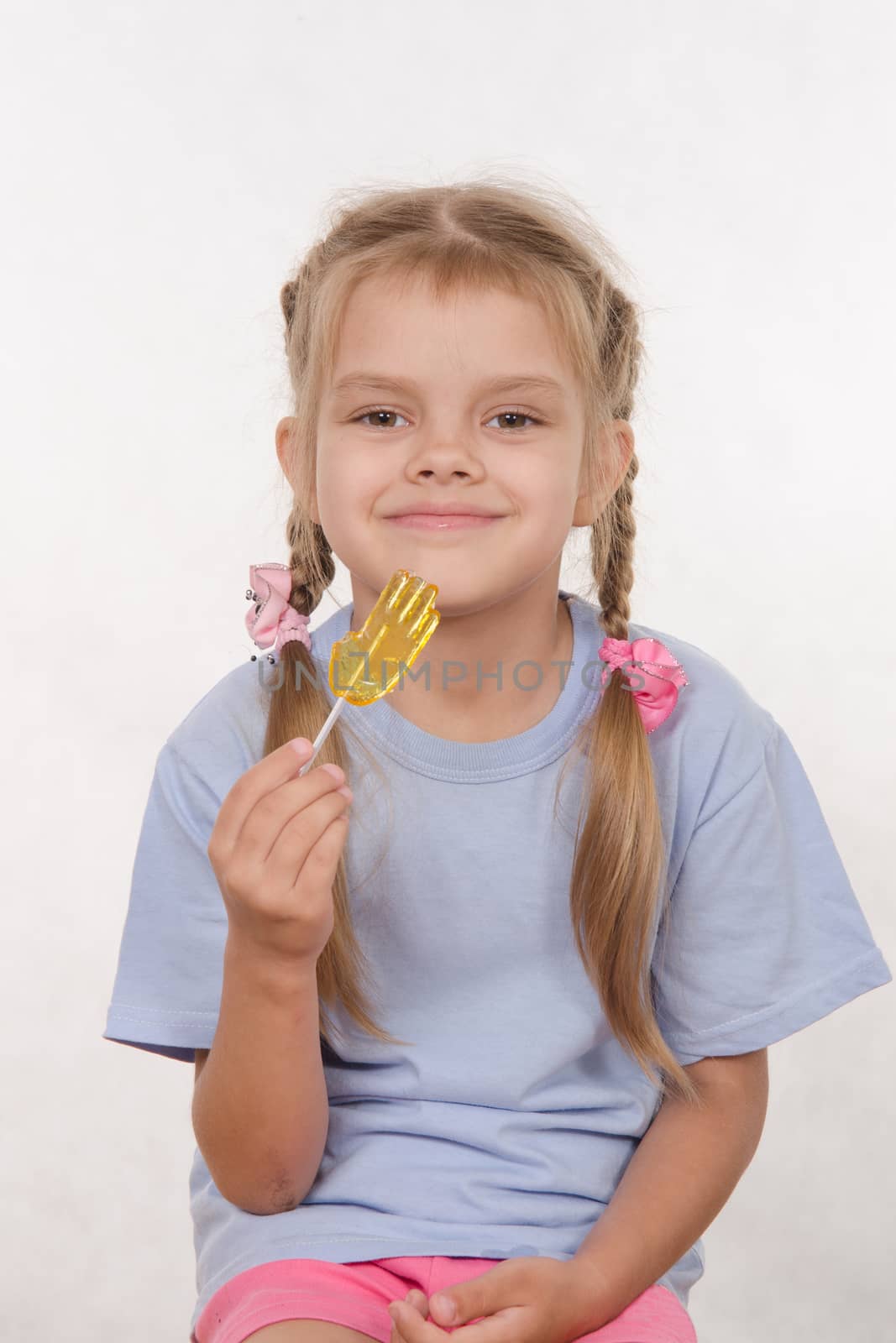 the five-year old girl enthusiastically eats candy