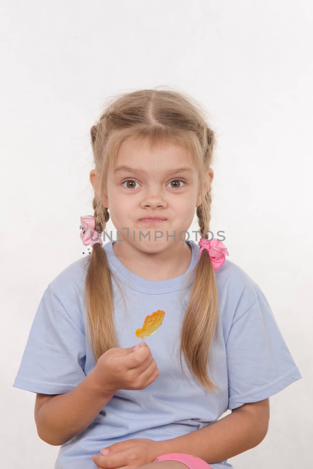 the five-year old girl enthusiastically eats candy
