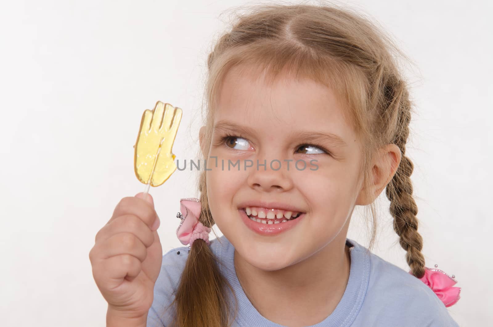 the five-year old girl enthusiastically eats candy