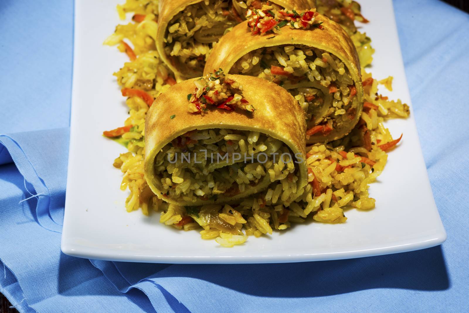 asian curry rice roll cutted as a sushi in a white plate on blue napkin