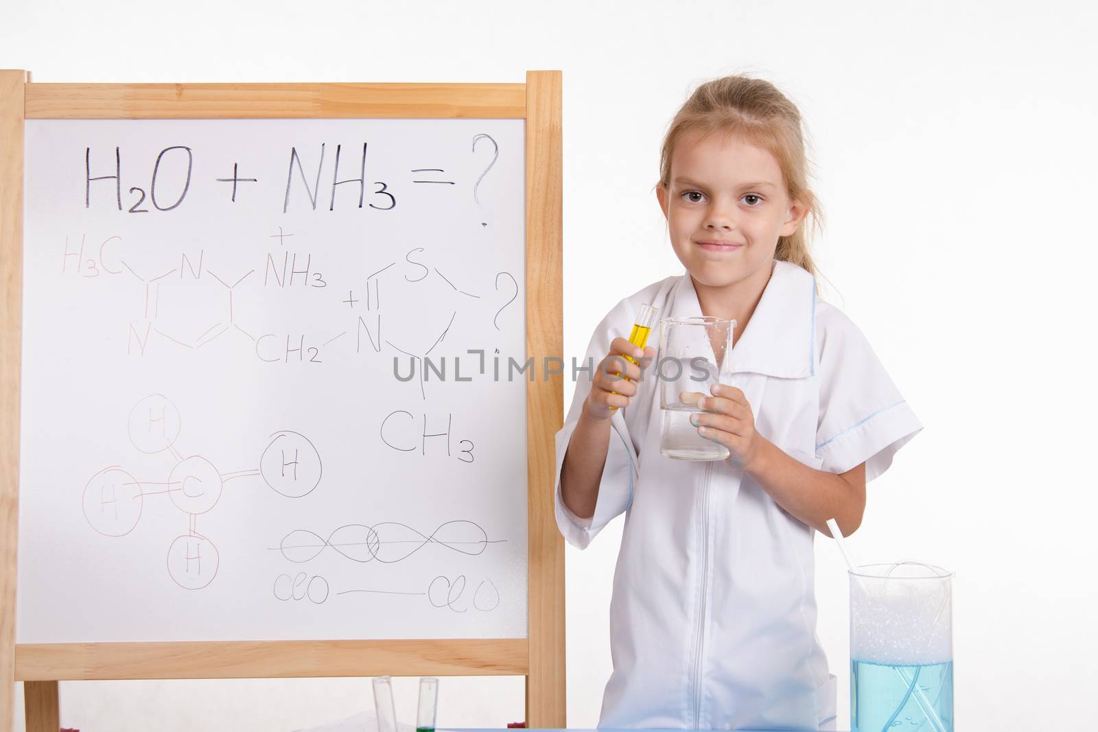 Five-year girl chemist standing at an easel in a bathrobe