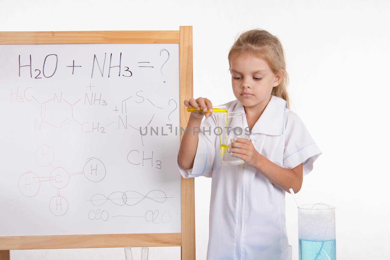 Five-year girl chemist standing at an easel in a bathrobe