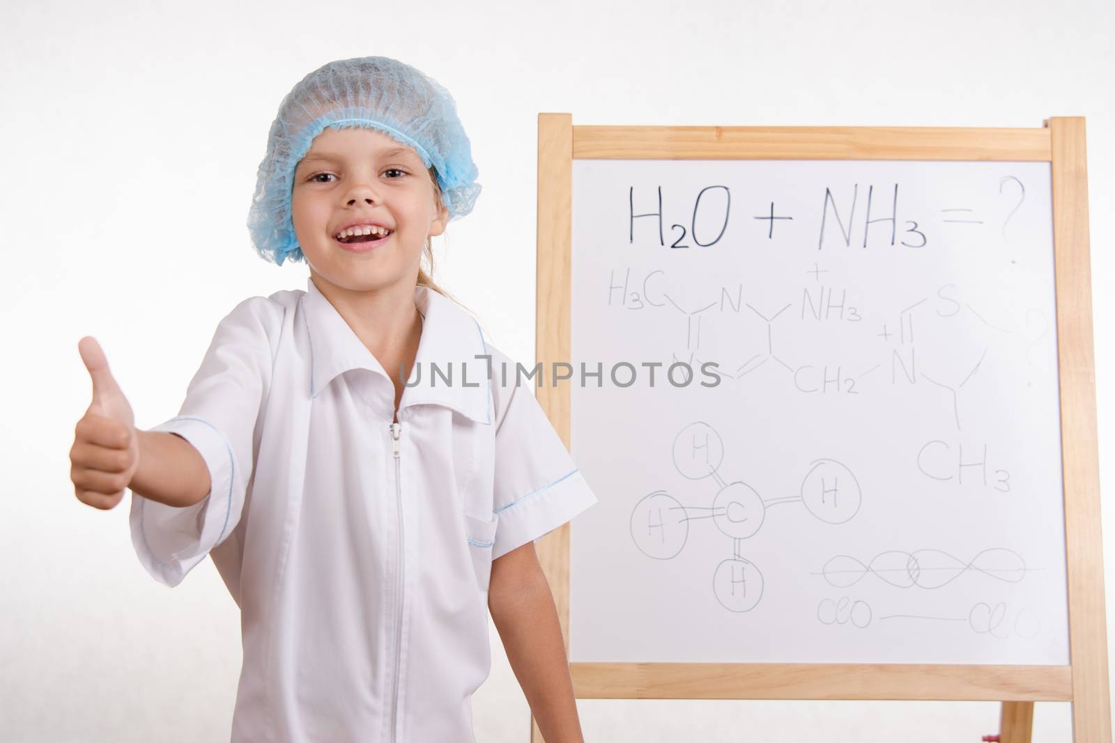 Five-year girl chemist standing at an easel in a bathrobe