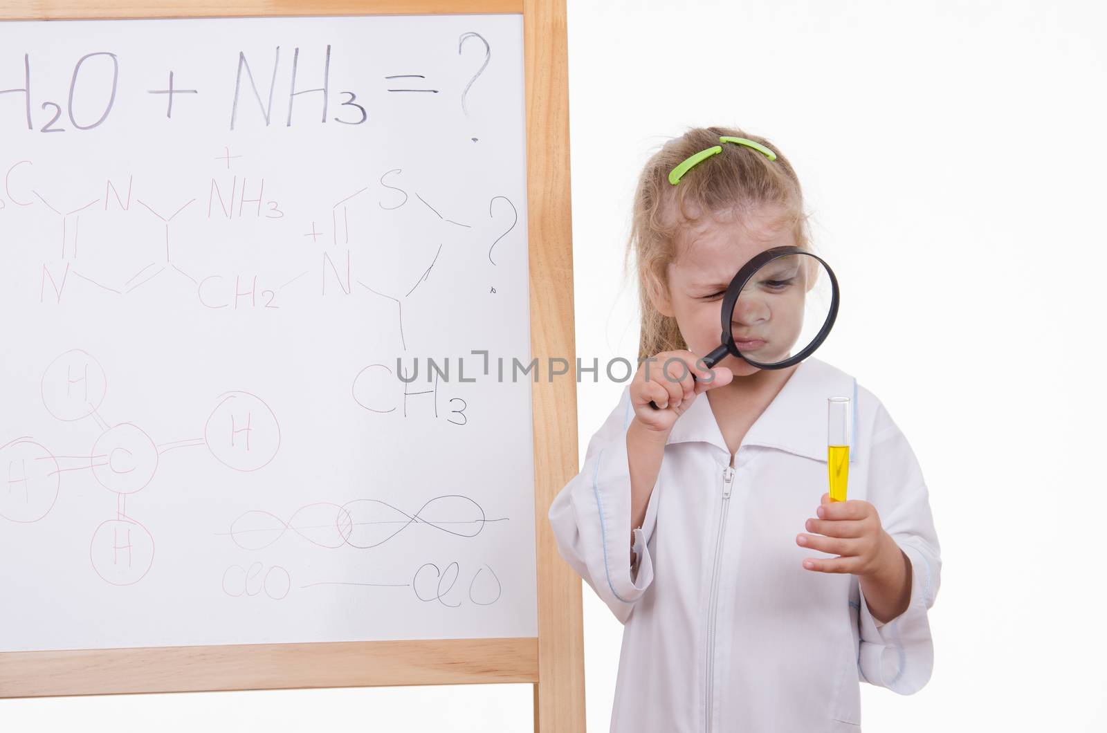 Three year old girl chemist standing at an easel in a bathrobe