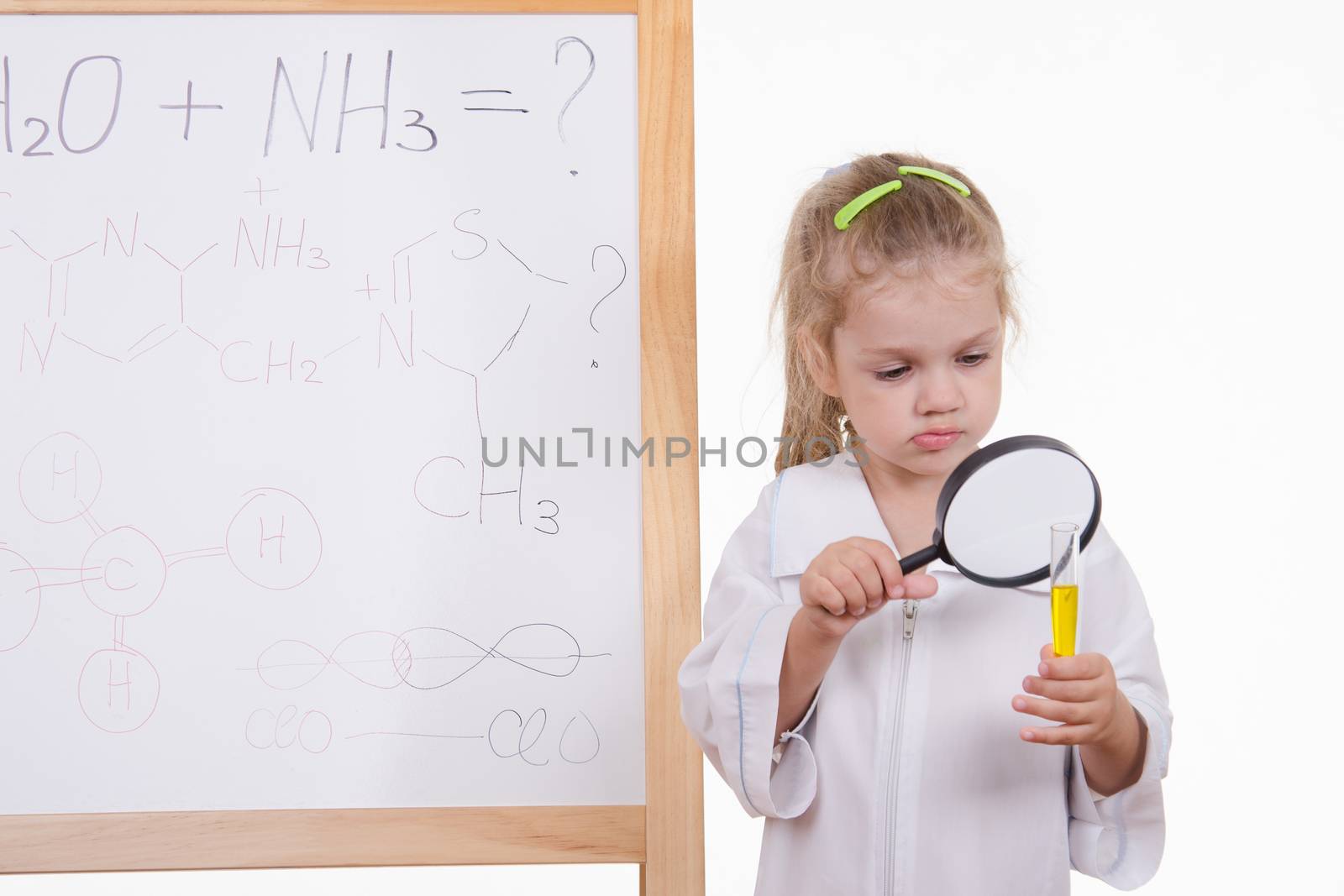 Three year old girl chemist standing at an easel in a bathrobe