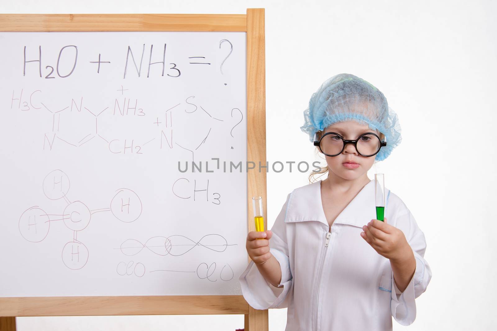 Three year old girl chemist standing at blackboard robe