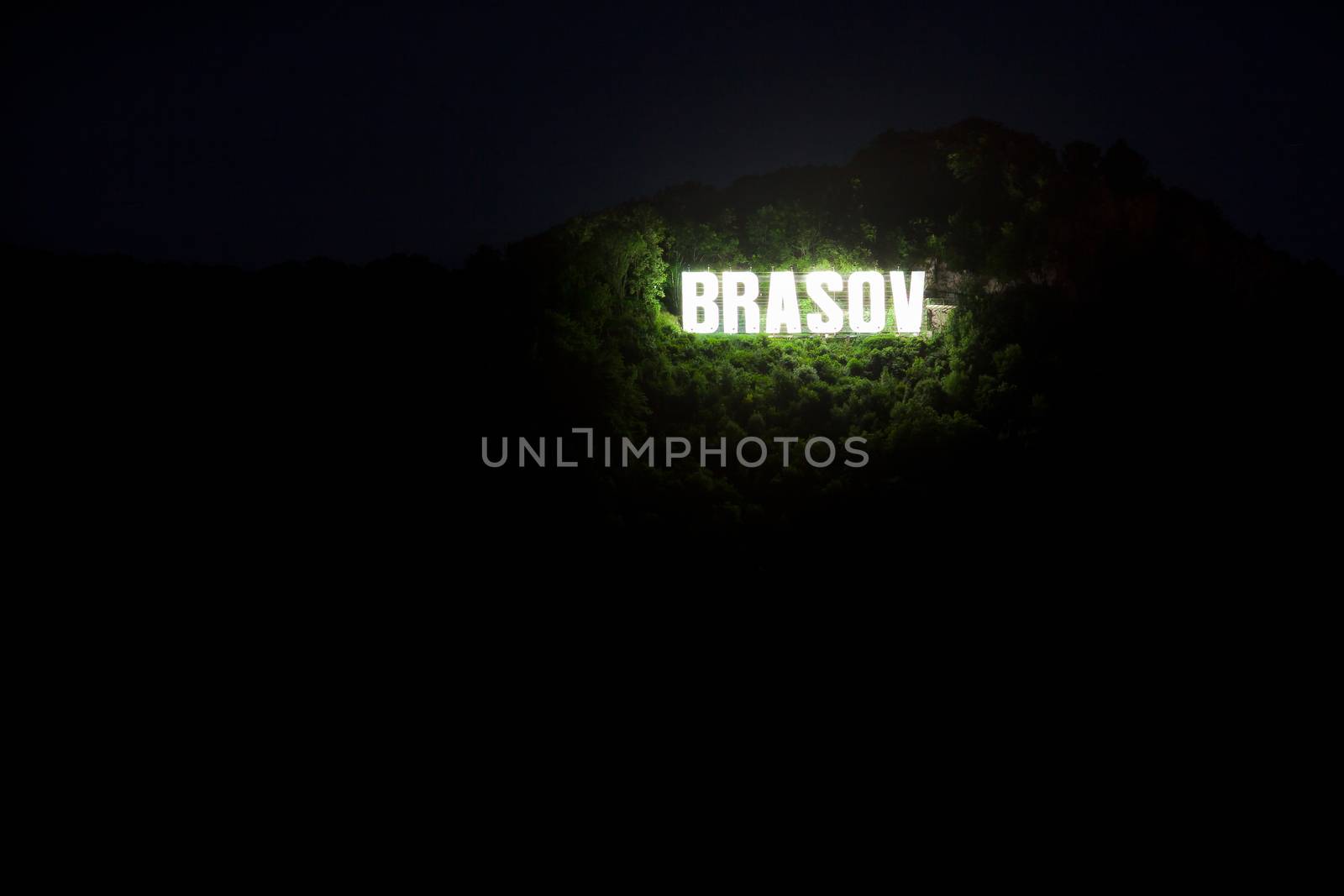Brasov city sign on top of Tampa mountain illuminated at night, Romania