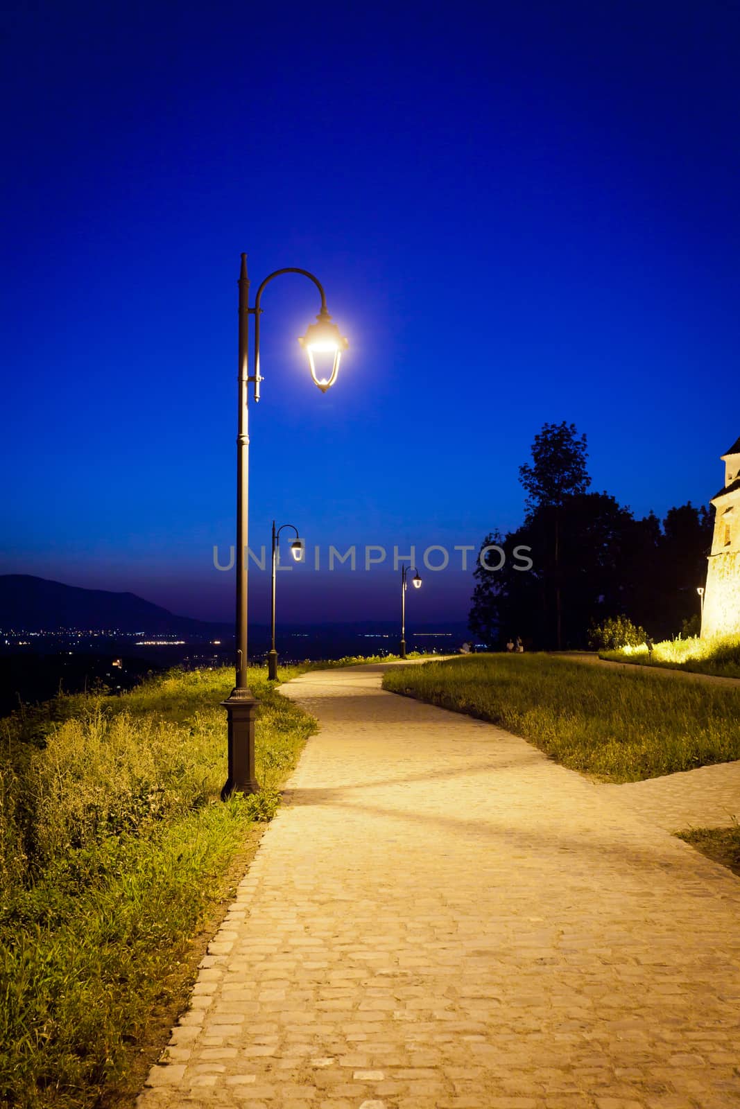 Alley arround old  fortress "Cetatuia" illuminated at night, Brasov, Romania