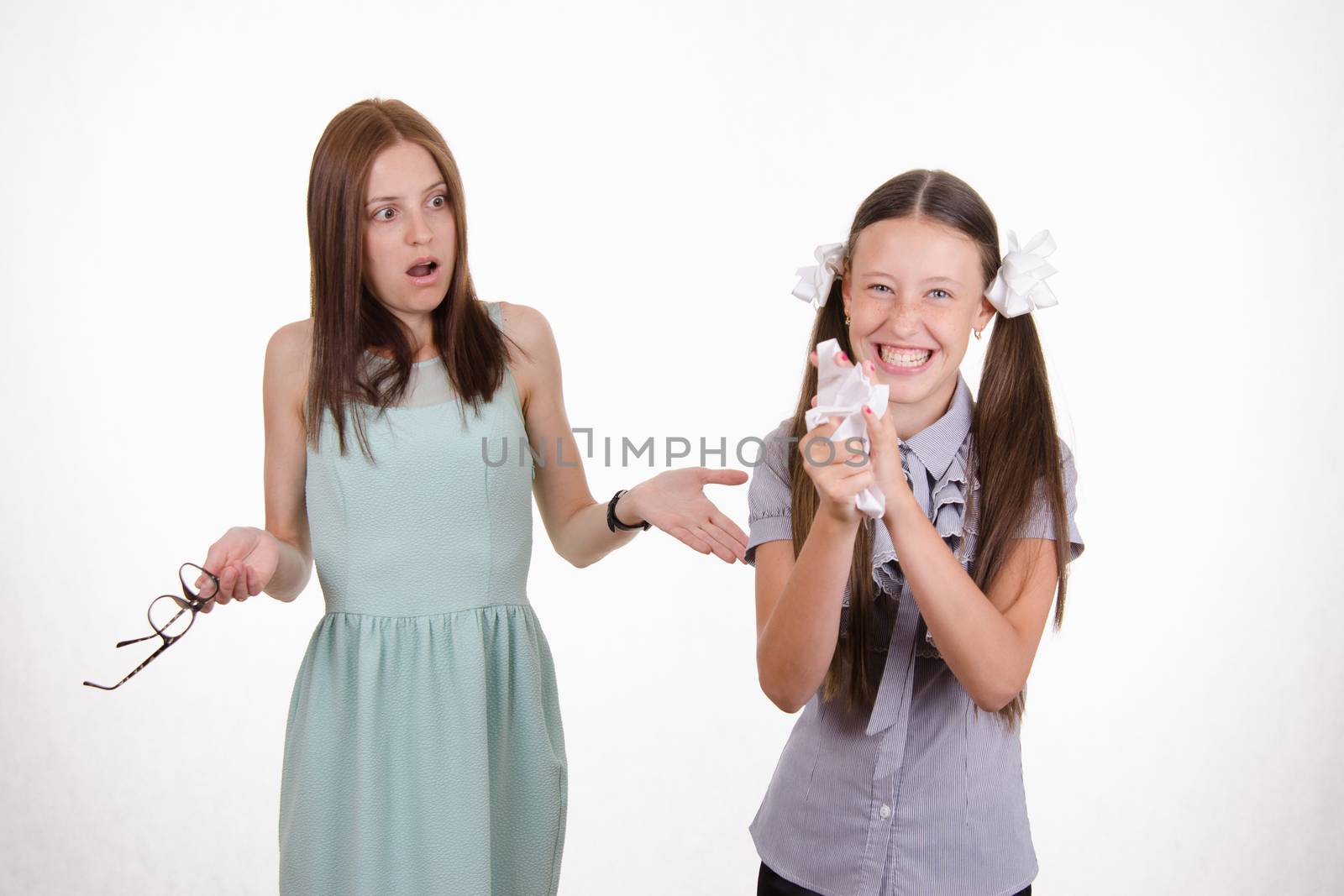 Schoolgirl having fun tearing the notebook in front of an angry teacher