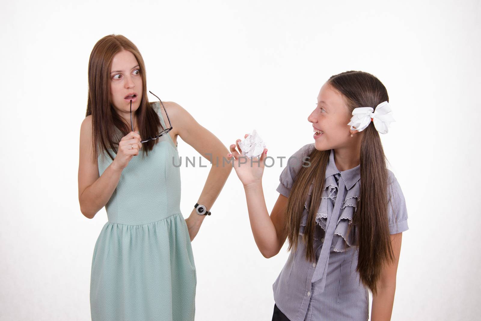 Schoolgirl having fun tearing the notebook in front of an angry teacher