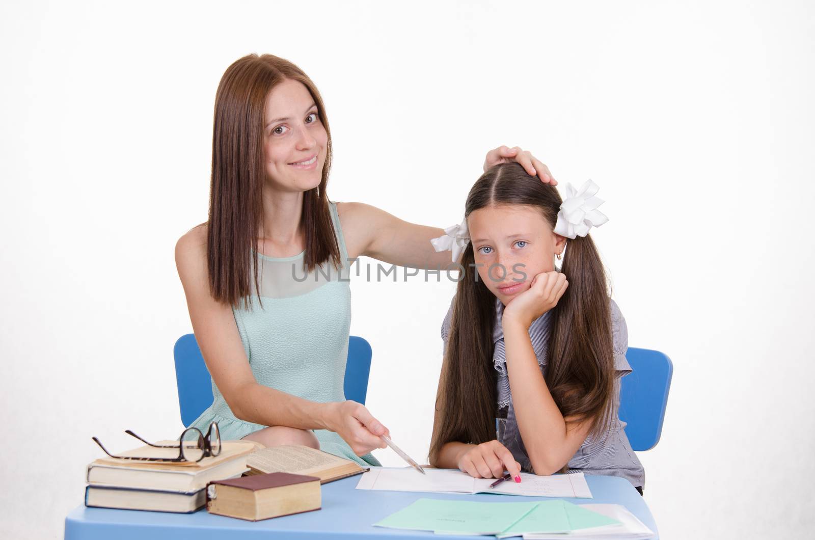 The teacher teaches the student sitting with him at the table