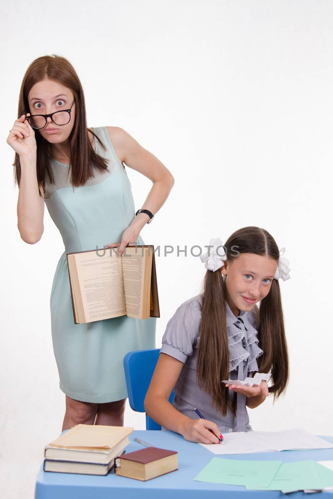 Teacher standing at desk behind which sits a pupil is deducted from the Crib