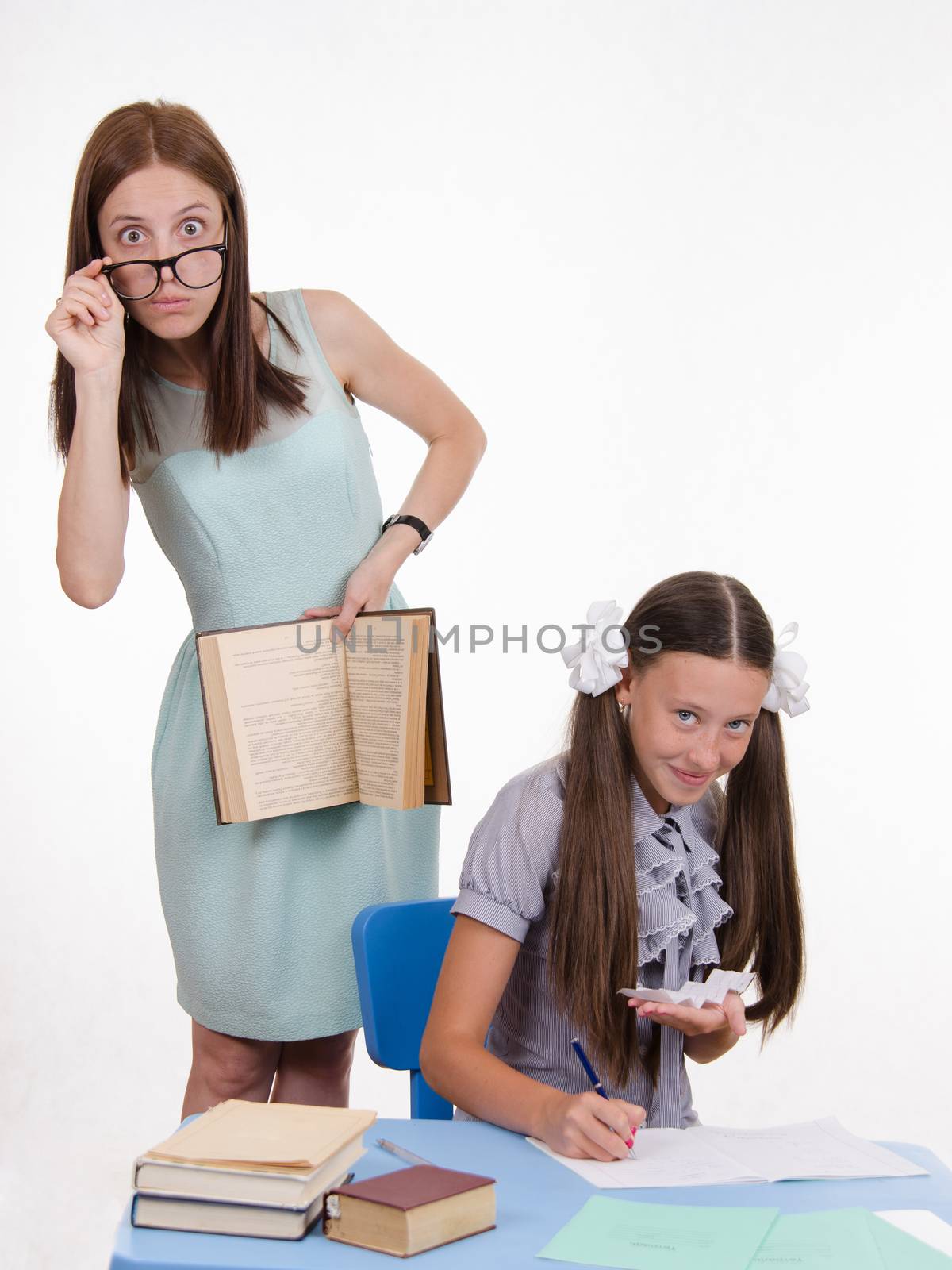 Teacher standing at desk behind which sits a pupil is deducted from the Crib