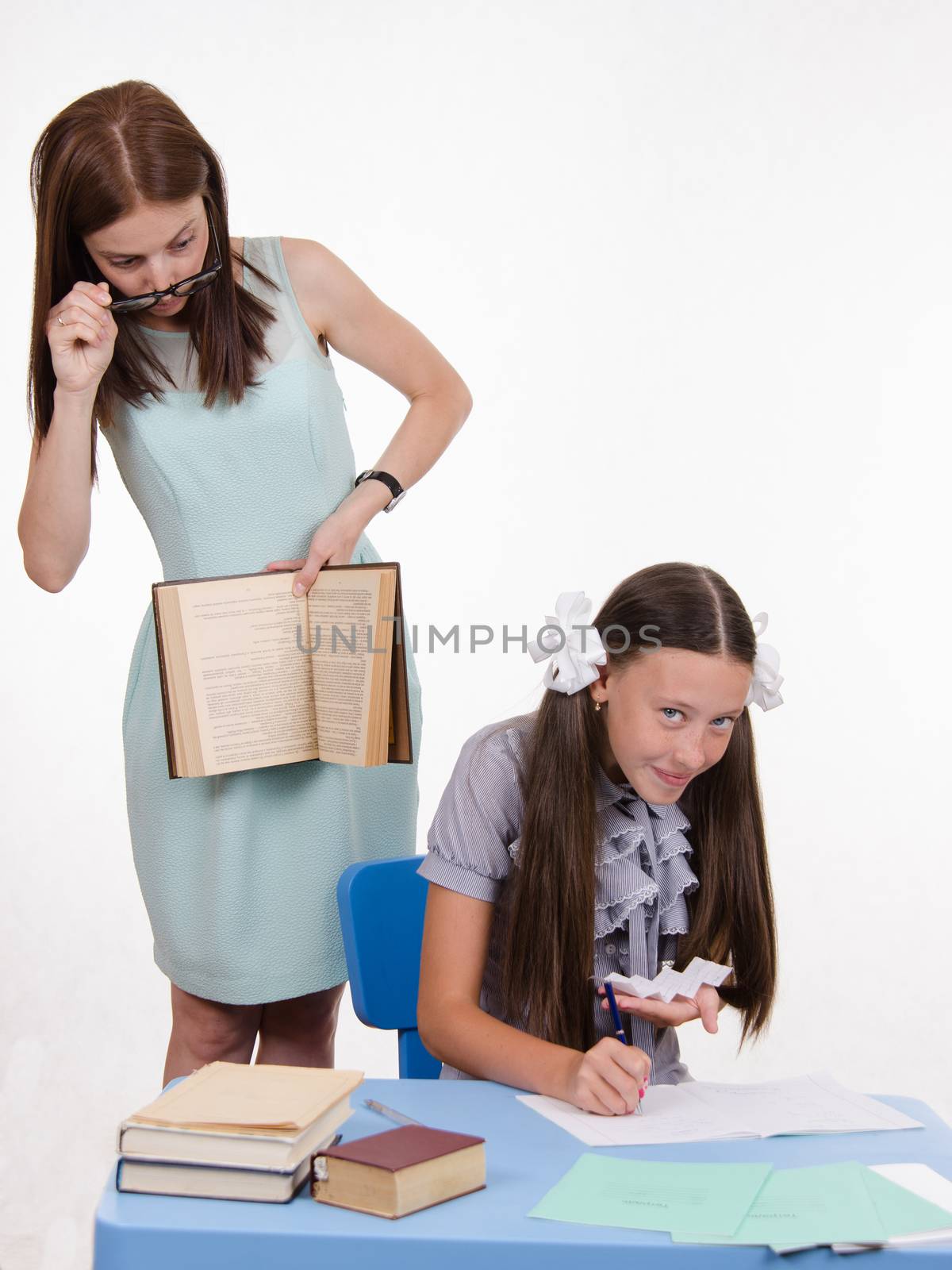 Teacher standing at desk behind which sits a pupil is deducted from the Crib
