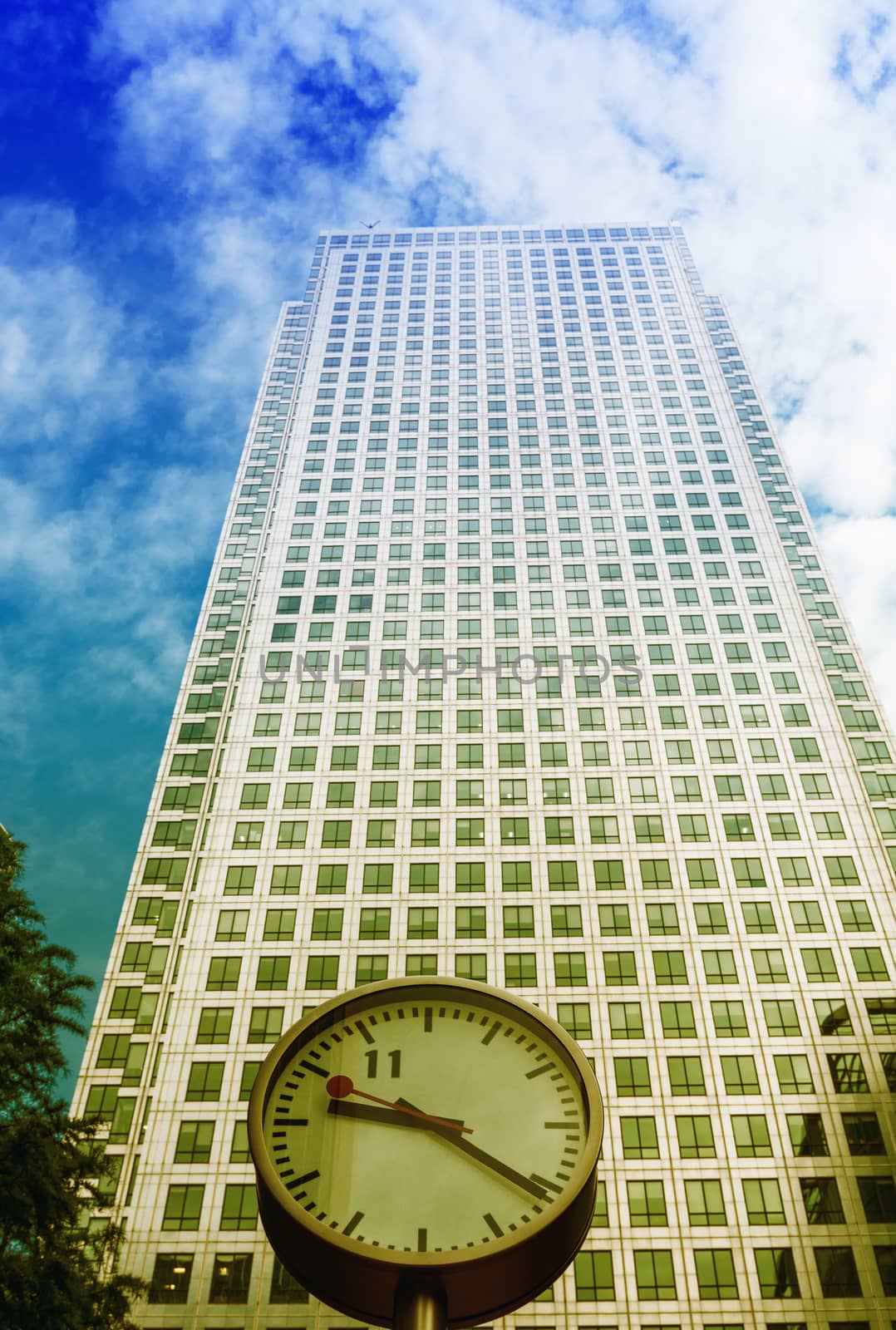 Clock and Skyscrapers at Canary Wharf, financial district in London. England.