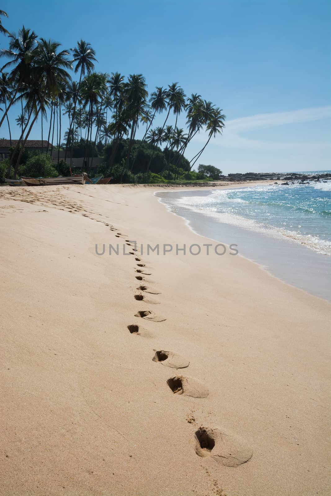 Footprints on paradise beach with coconut trees and white sand, Tangalle, Southern Province, Sri Lanka, Asia.