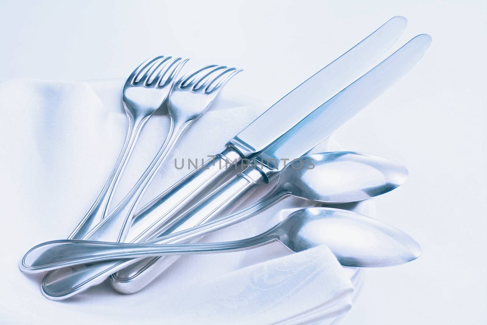 silverware - closeup of elegant knife fork and spoon on white cloth