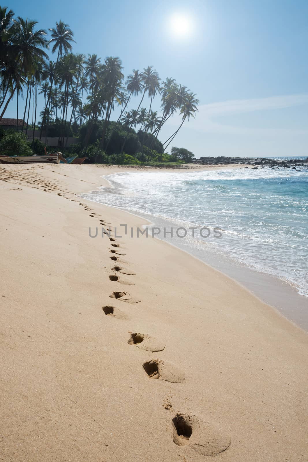 Footprints on paradise beach with coconut trees and white sand, Tangalle, Southern Province, Sri Lanka, Asia.