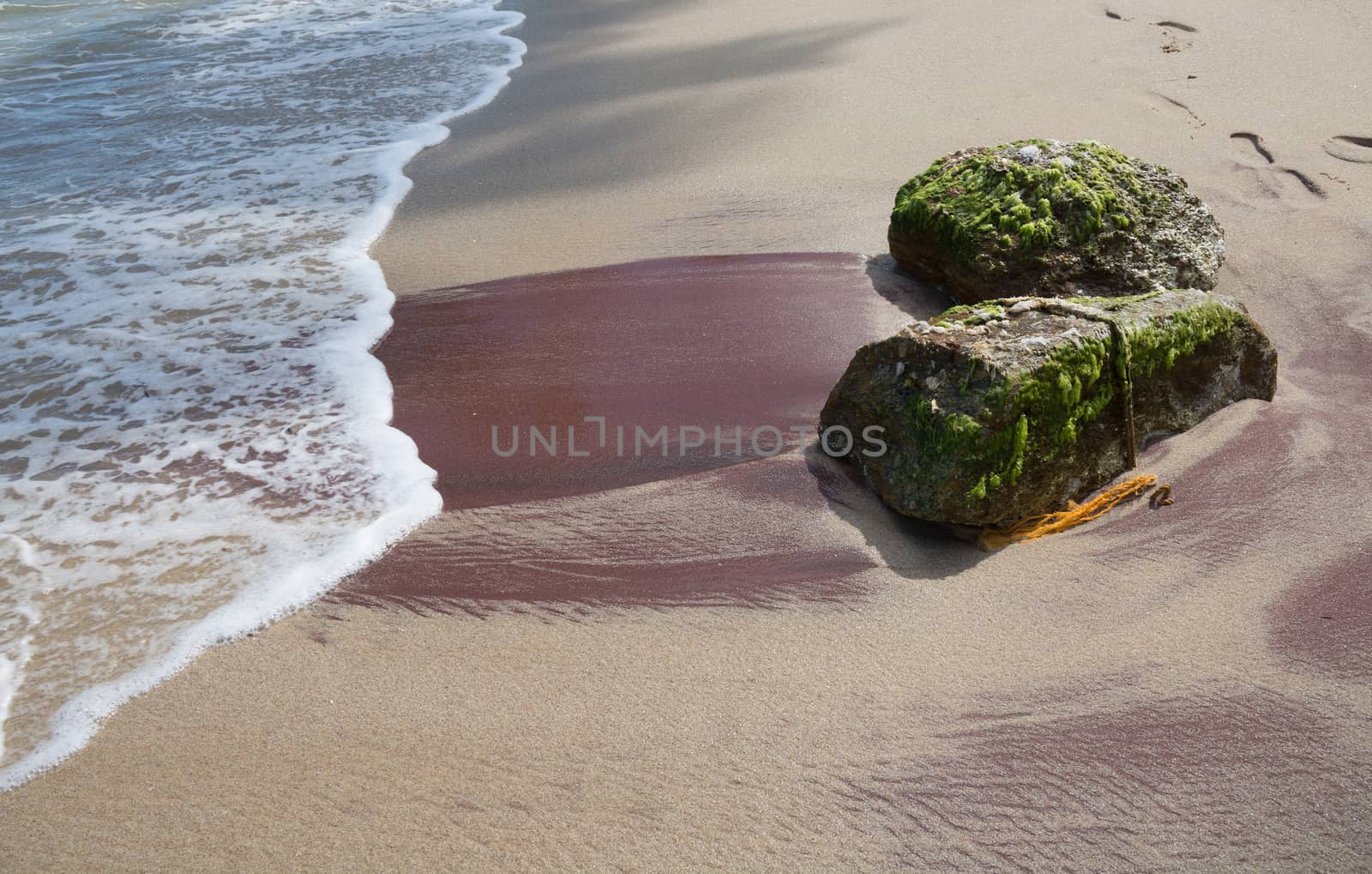 Sandy beach with red mineral deposits in Tangalle, Southern Province, Sri Lanka, Asia.