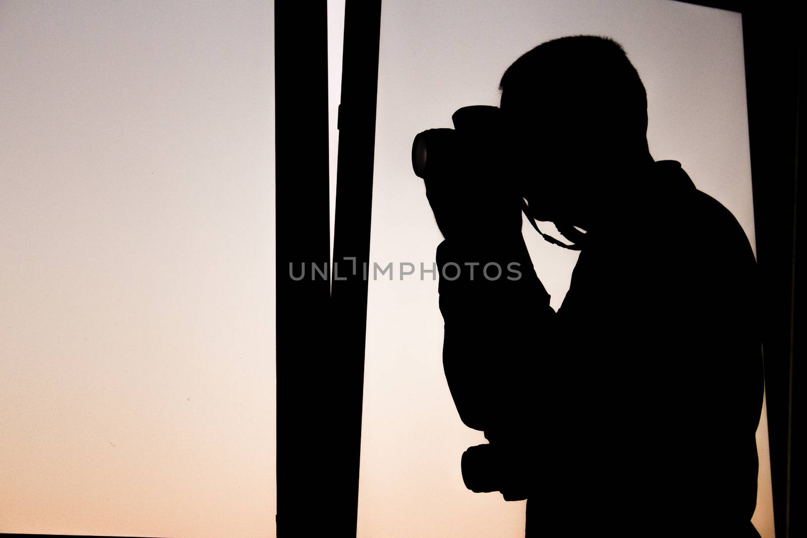 Silhouette photograph with purple sky background. Camera ready to shoot photos. Photograph.