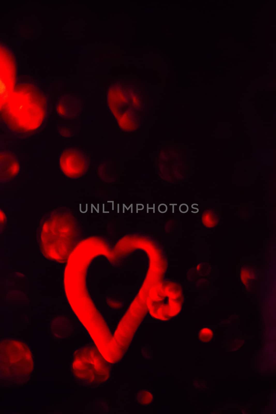 Red Heart with cotton clouds on black background. Vertical rectangular artistic color digital photo.