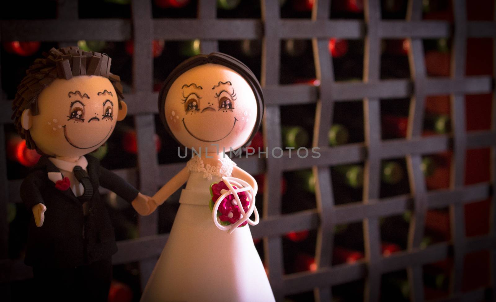 Wedding Cake Figurine formed by the bride and groom for the wedding cake. Dark background with ball and red and green dots.