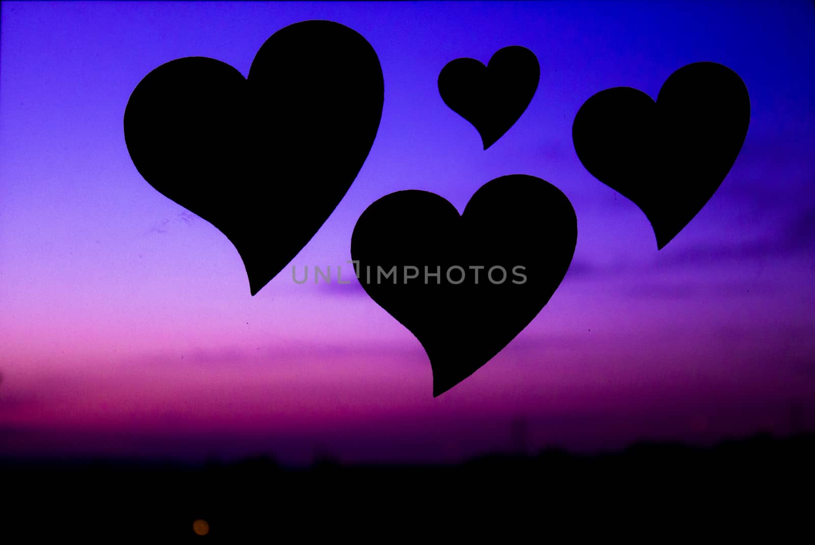 Three hearts floating in the blue sky and purple.